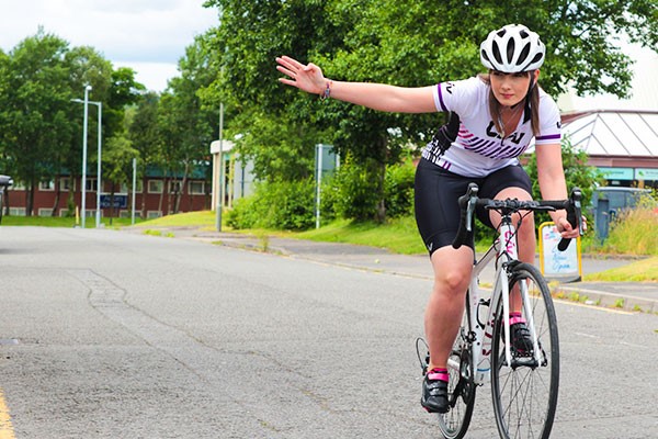 Female cyclist signalling on bike
